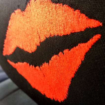 Close-up of red Kiss Lip embroidery on black Betty Boop headrest cover